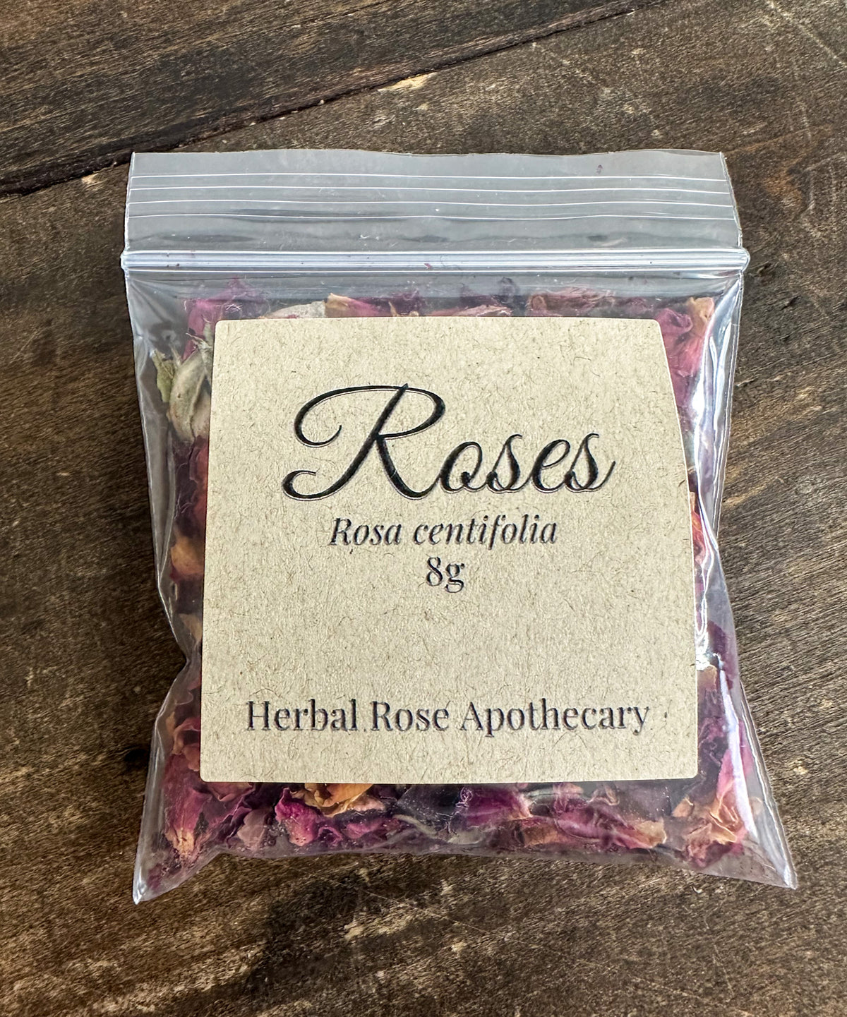 dried roses in 8g clear resealable bag on a wooden surface