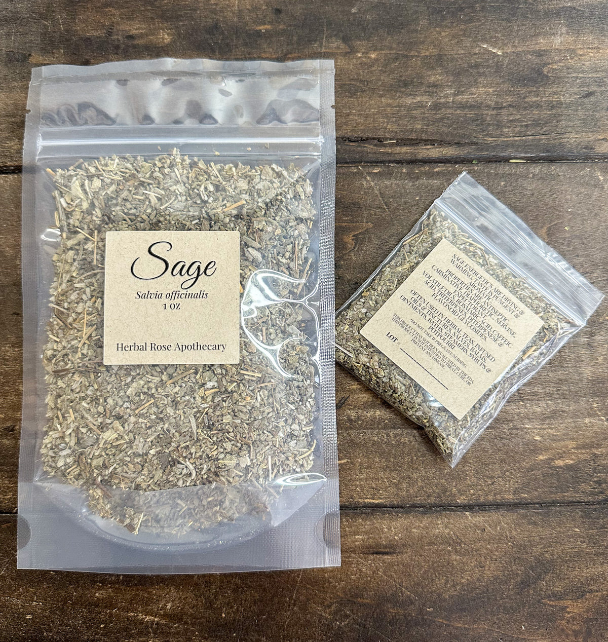 two packages of dried sage leaves in clear resealable bags from herbal rose apothecary on a wooden surface