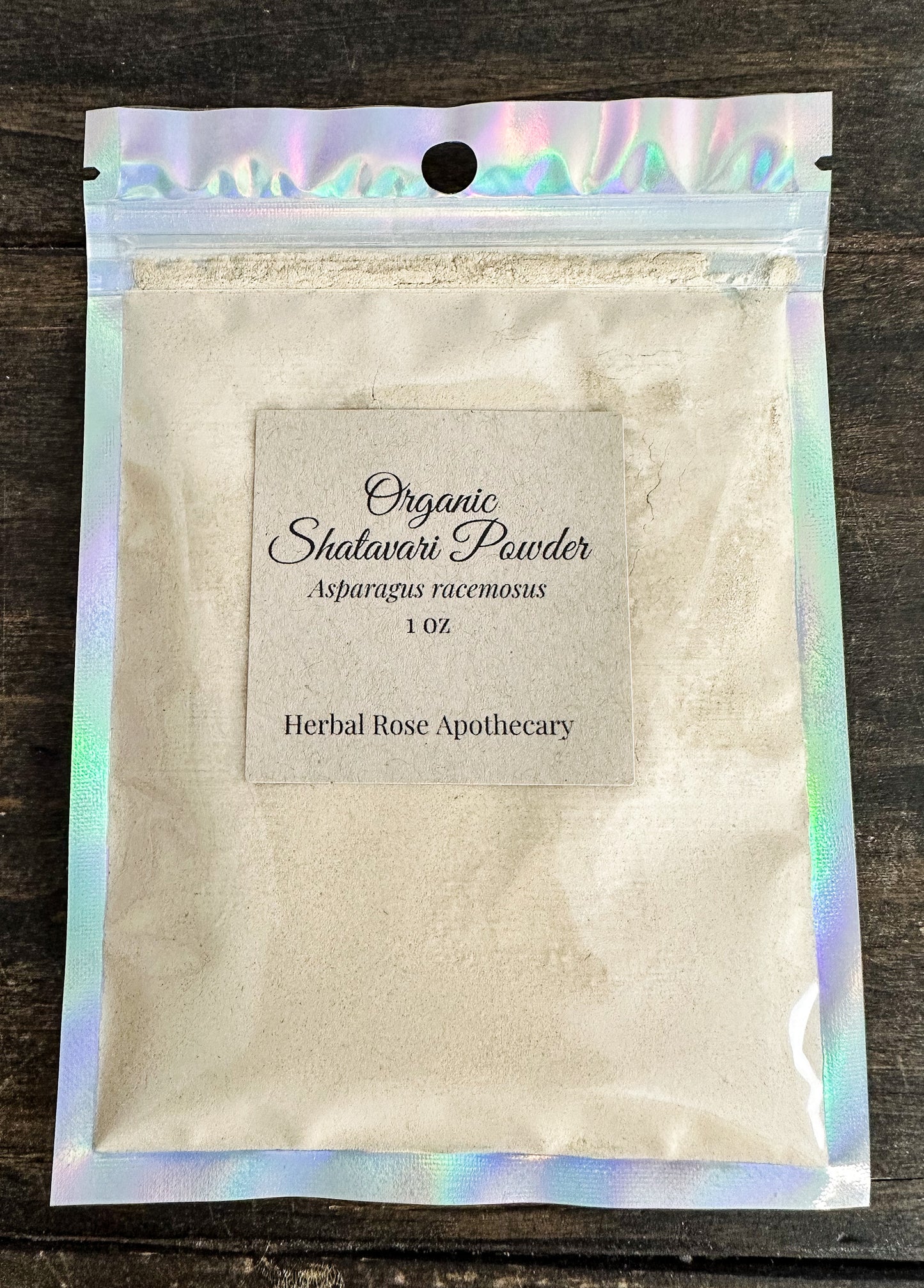 Shatavari powder package with holographic top on a wooden surface