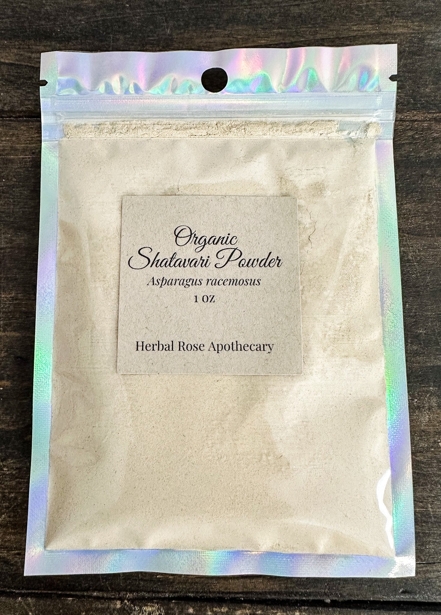 Shatavari powder package with holographic top on a wooden surface