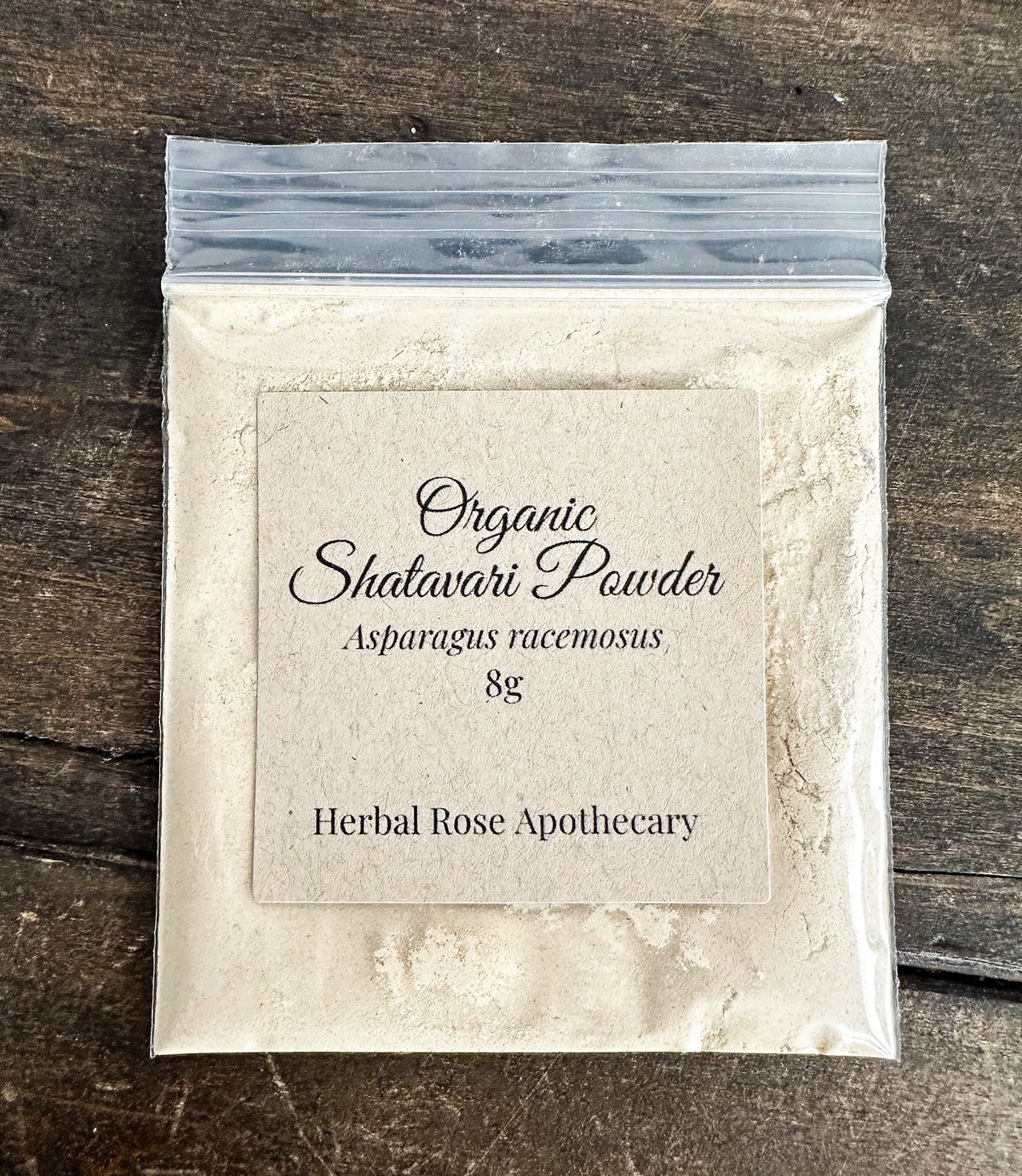 dried organic shatavari powder 8g bag in clear resealable bag on wooden surface