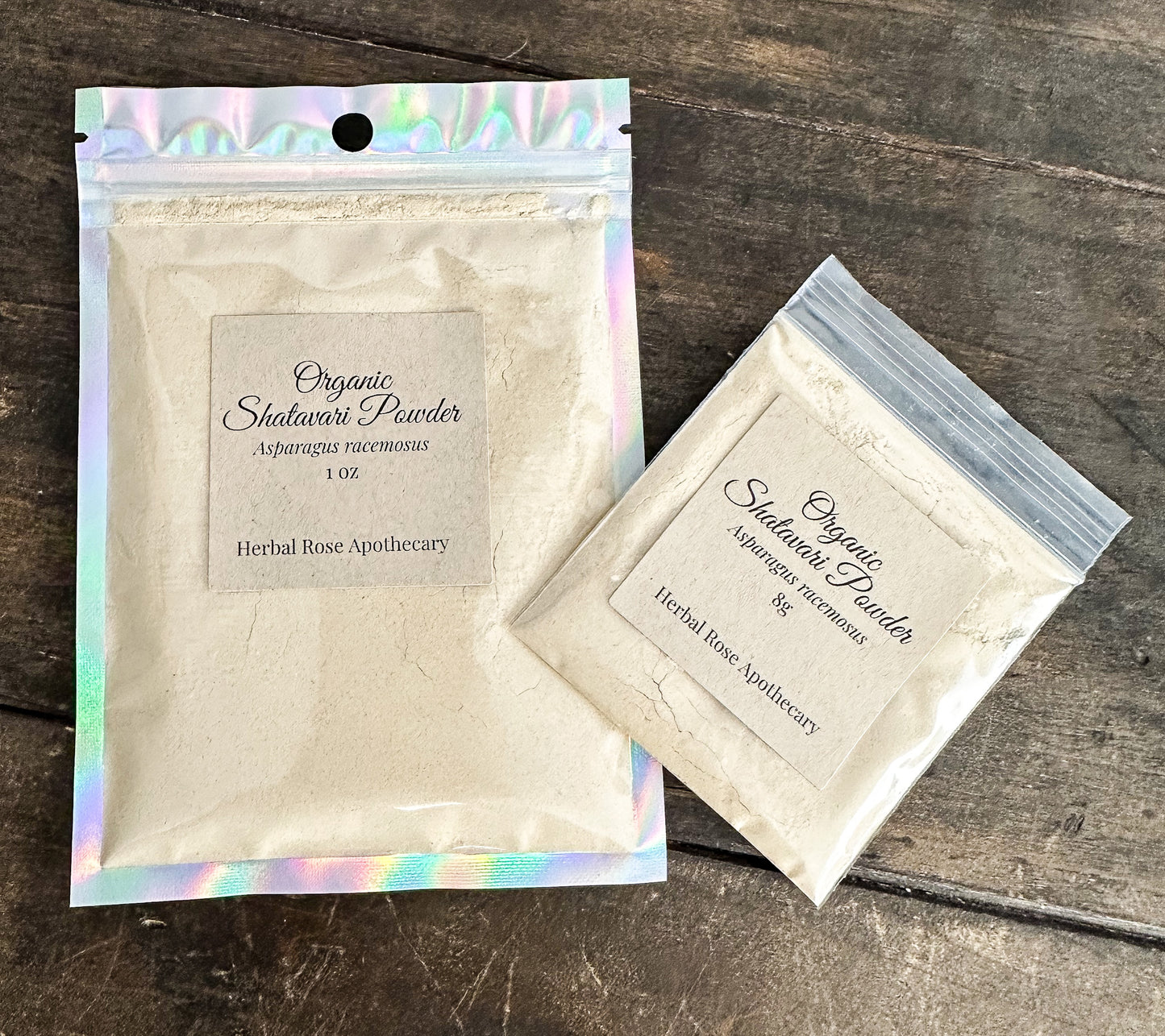 Two packages of Organic Shatavari Powder from Herbal Rose Apothecary on a wooden surface.