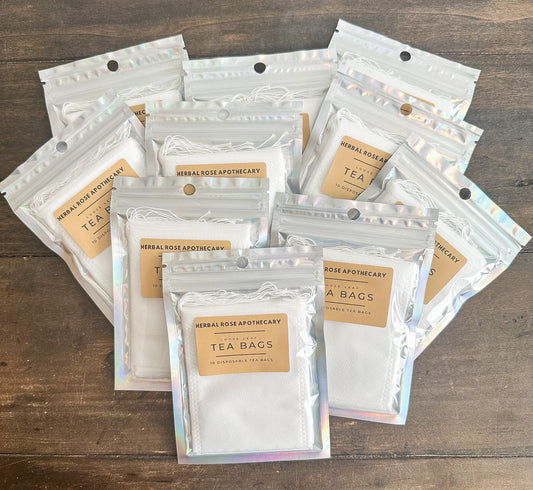 10 pack of tea bags in holographic bags laid out on a wooden surface