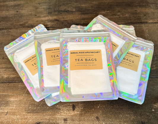 5 pack of tea bags in holographic bags on a wooden surface