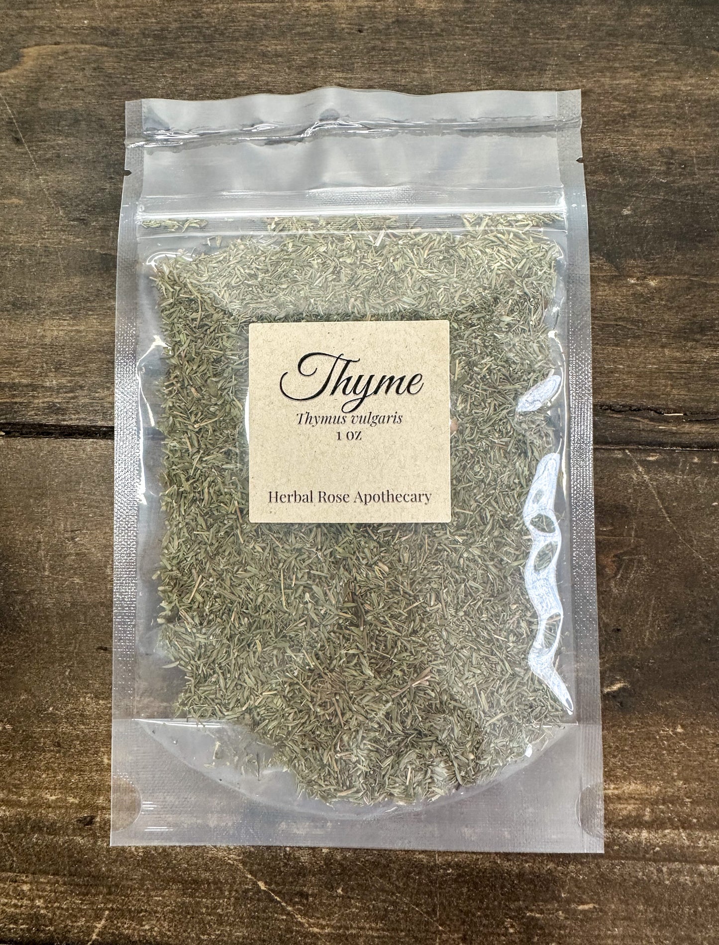 dried thyme leaves in 1oz clear resealable bag on a wooden surface