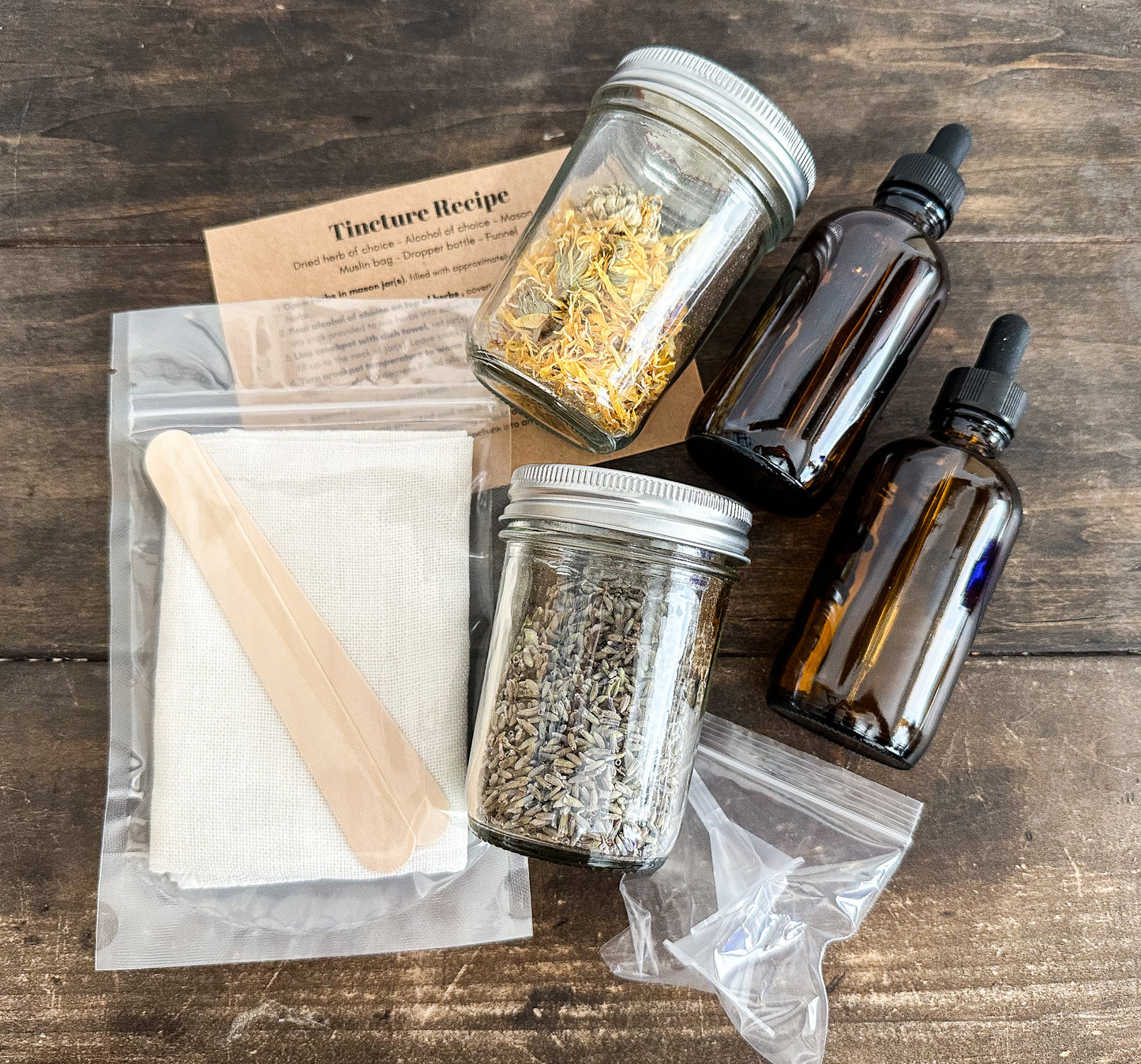 DIY tincture kit laid out with all supplies included in kit on a wooden background