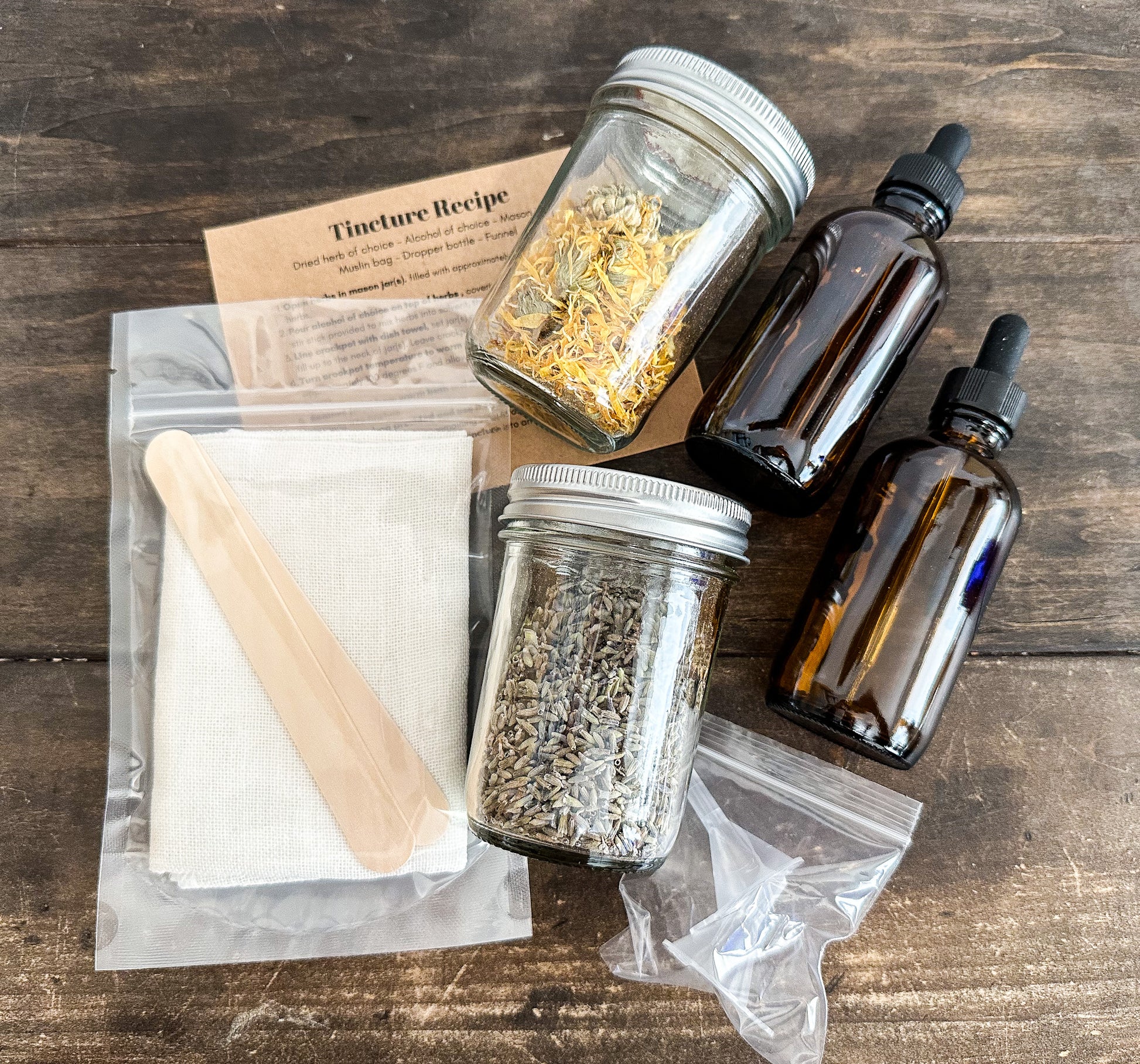 DIY tincture kit laid out with all supplies included in kit on a wooden background