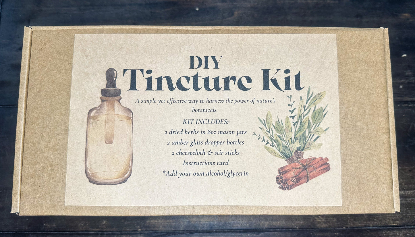DIY Tincture Kit in a square kraft paper box with a large cream-colored front label. The label features an illustration of a glass dropper bottle, text detailing the kit contents, and an illustration of green herbs and cinnamon sticks.