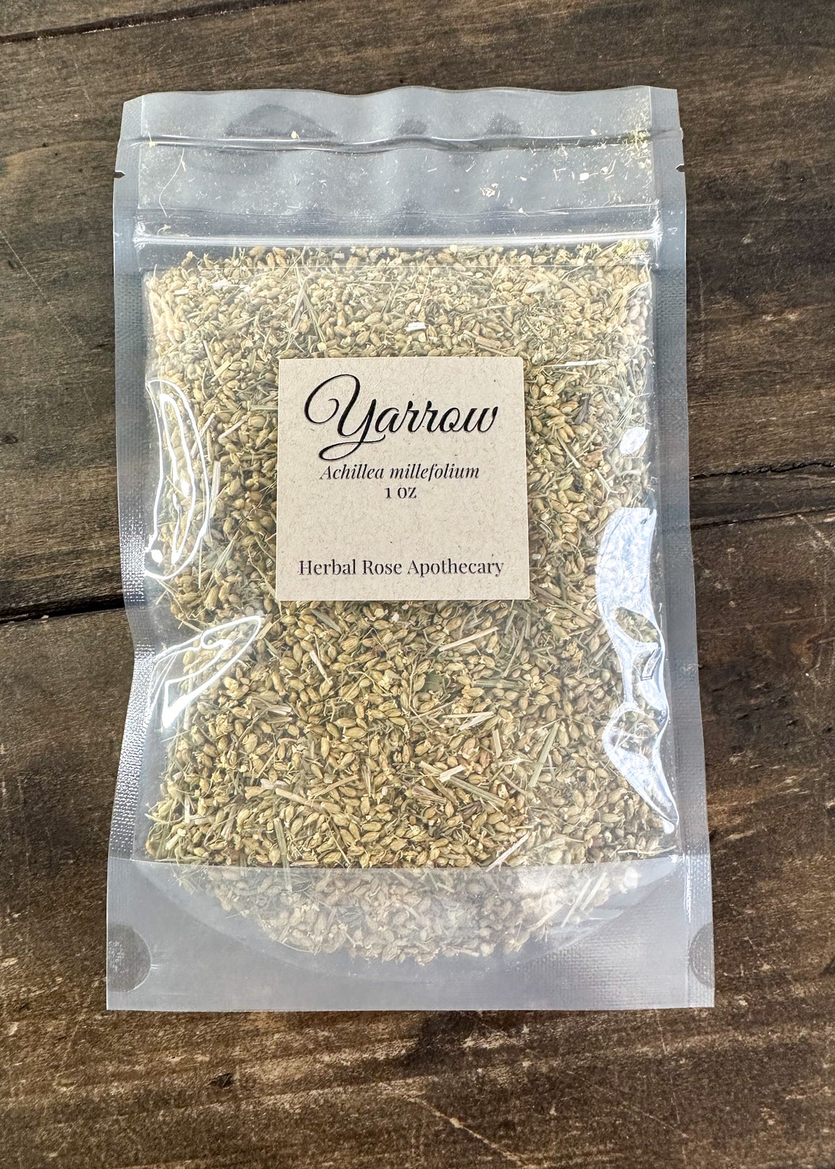 dried yarrow in 1oz clear resealable bag on wooden surface