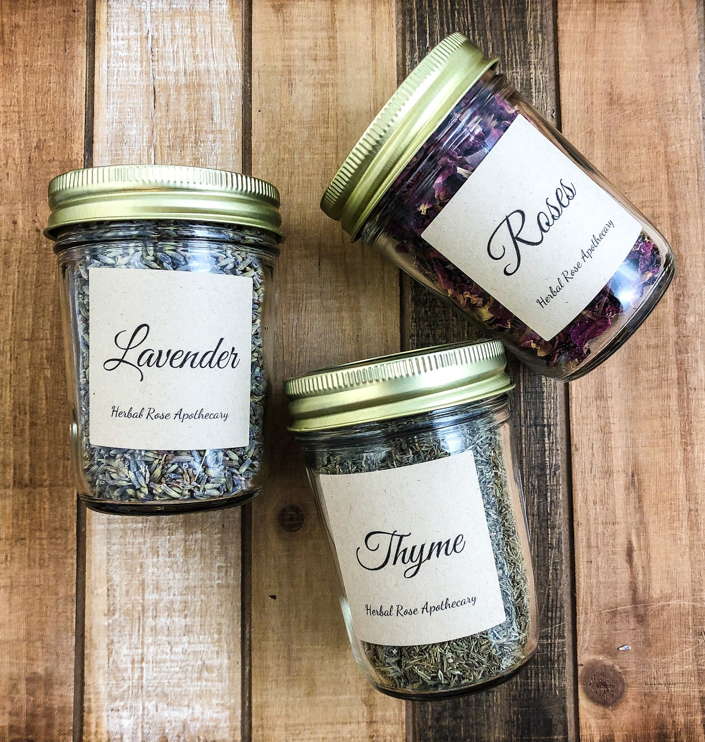 dried herbs in jars, 3 mason jars laying on a wooden background 