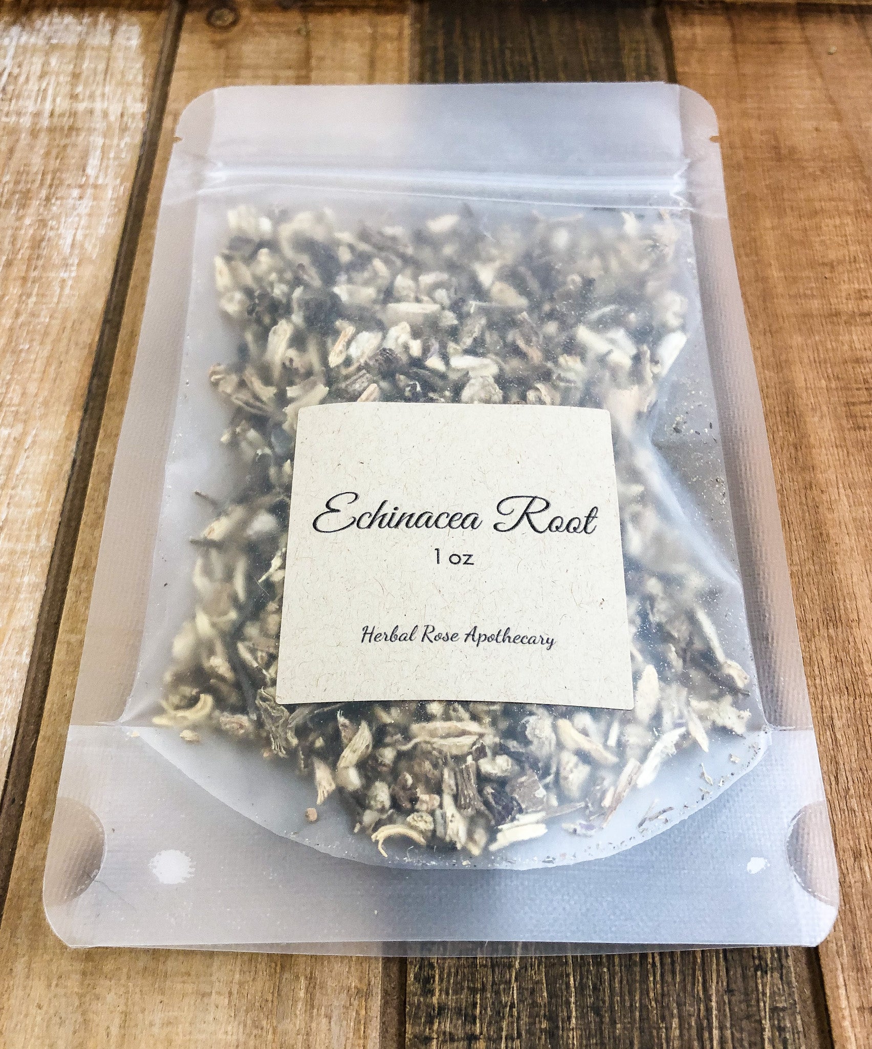 1oz bag of dried echinacea root in a clear plastic bag with a wooden background