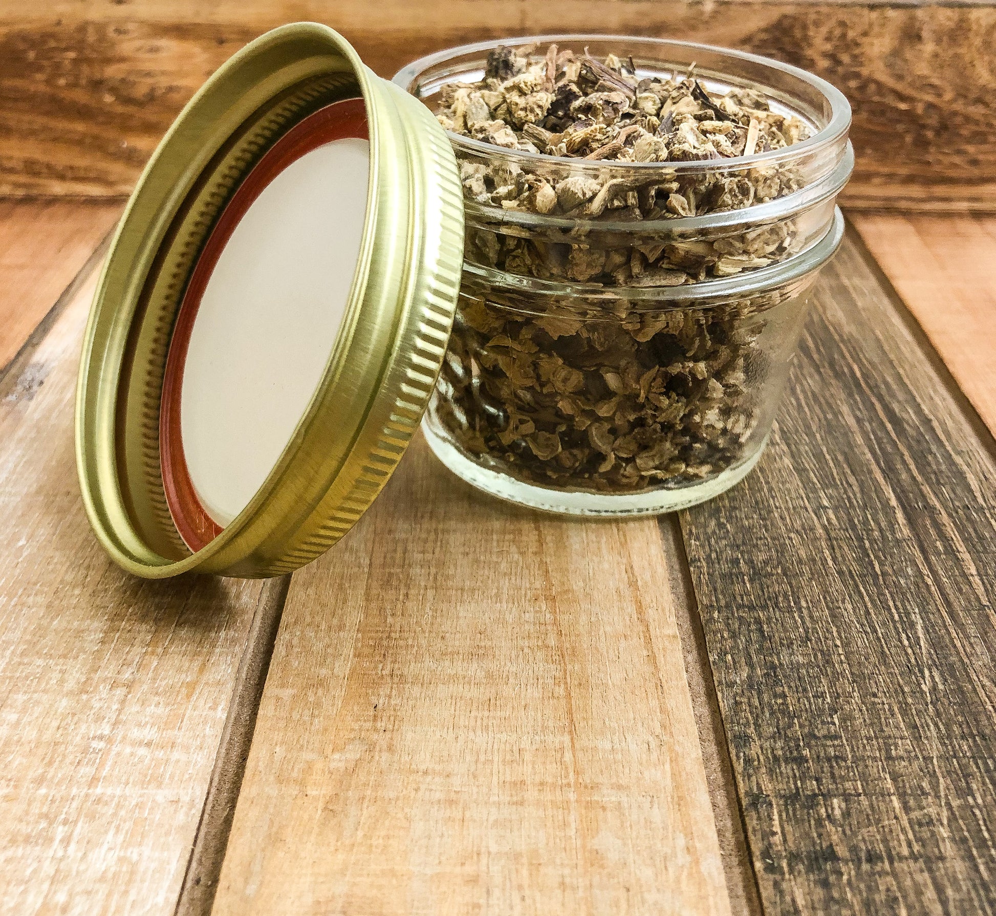 dried echinacea root in a clear mini mason jar with a wooden background