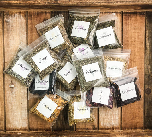 Ariel image of herbal sample pack of bulk dried herbs in 8g bags laying on a wooden table as a background