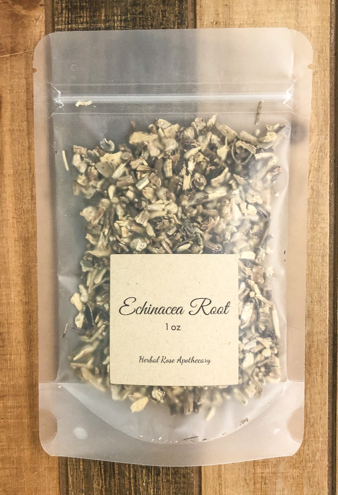 1oz bag of dried echinacea root in a clear plastic bag with a wooden background