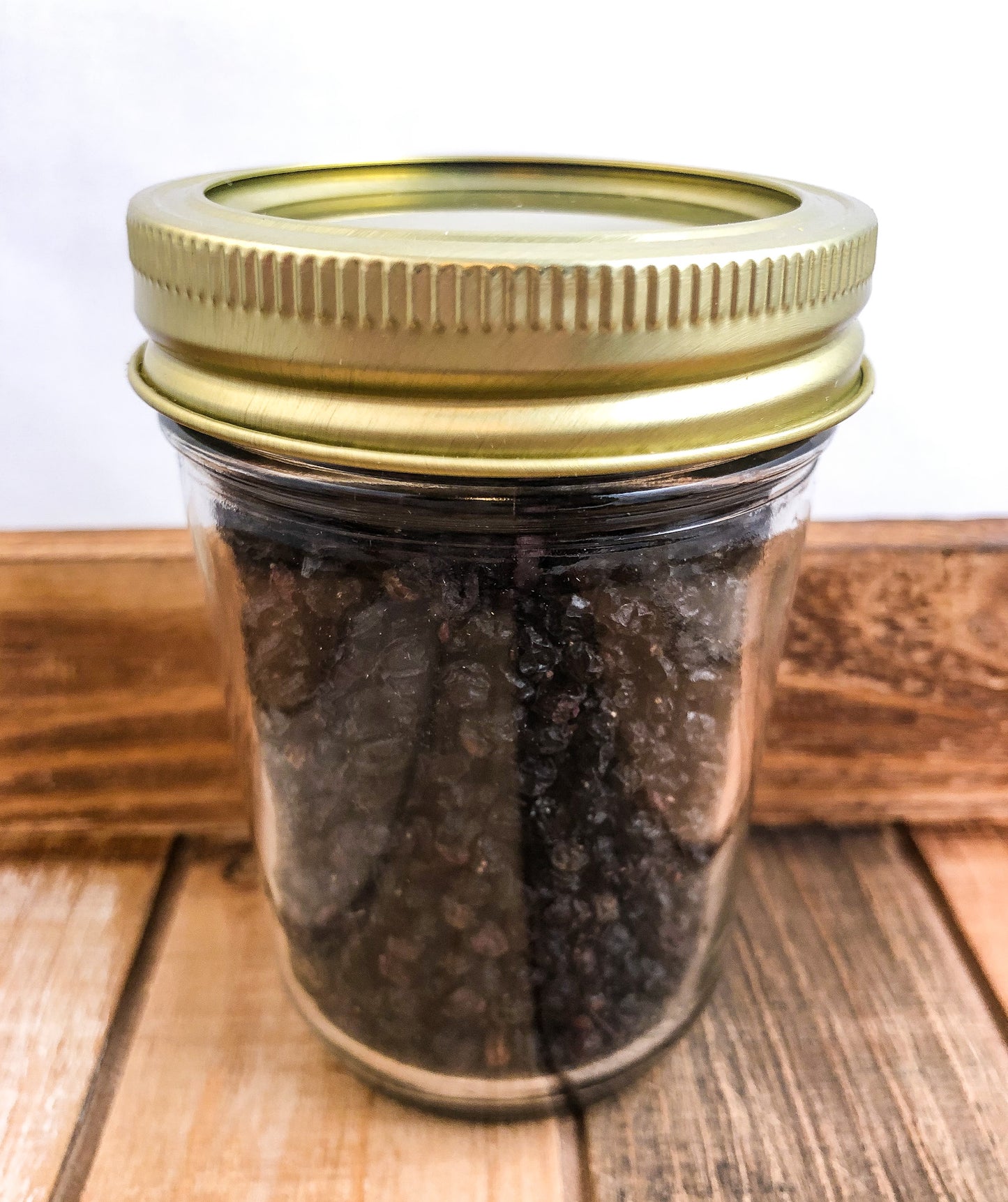 dried elderberry in small jar with wooden background