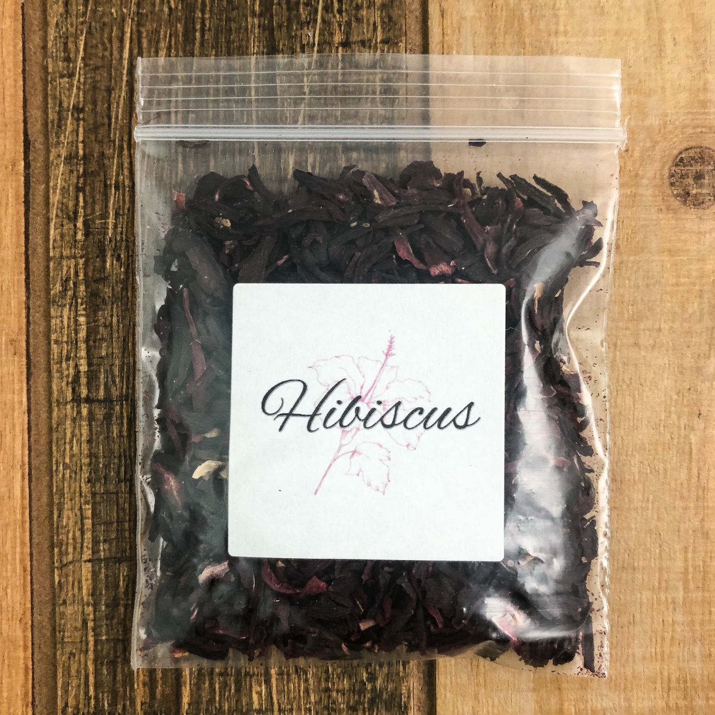8g bag of dried hibiscus in a clear plastic bag with a wooden background