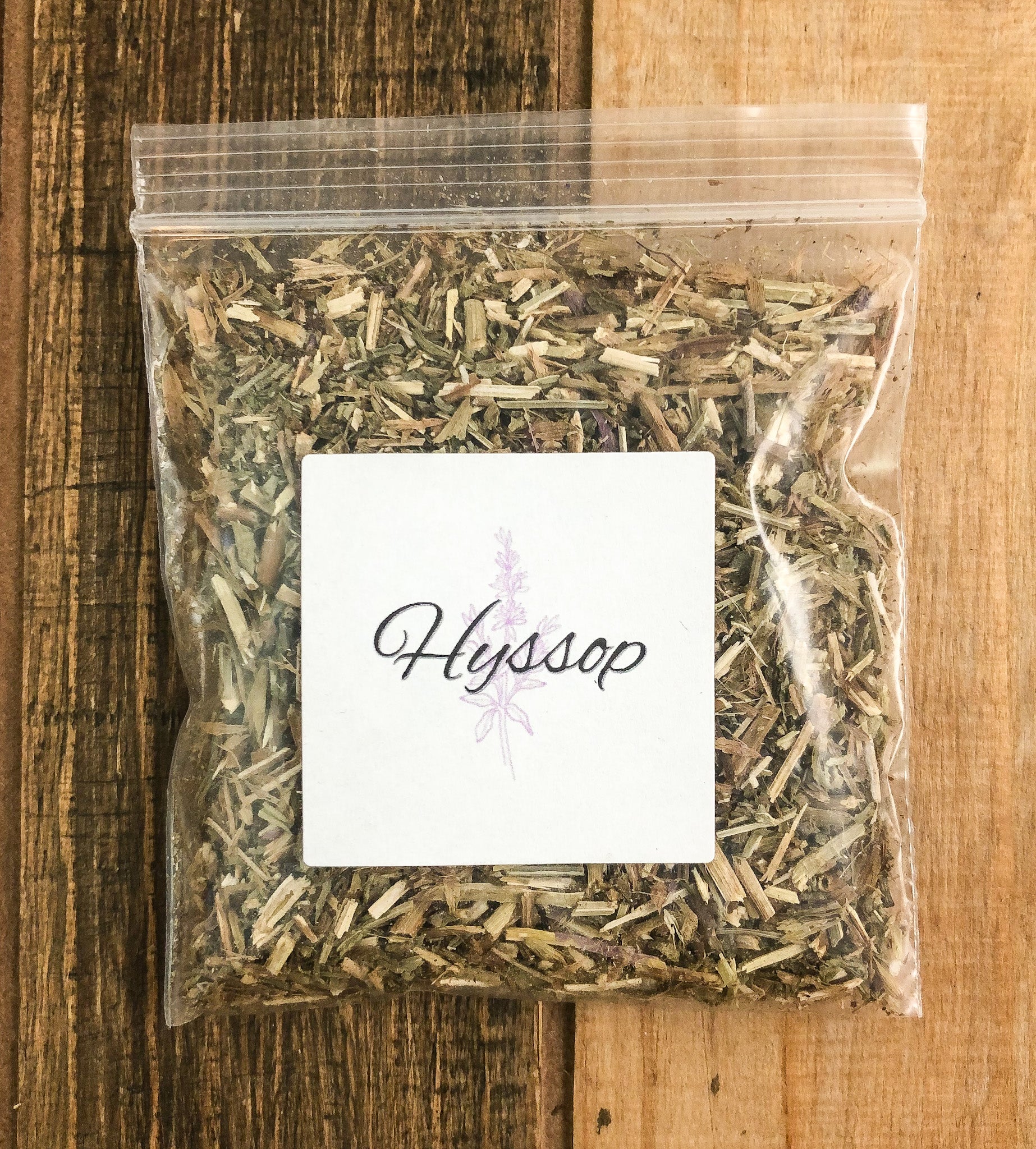 8g bag of dried hyssop in a clear plastic bag with a wooden background