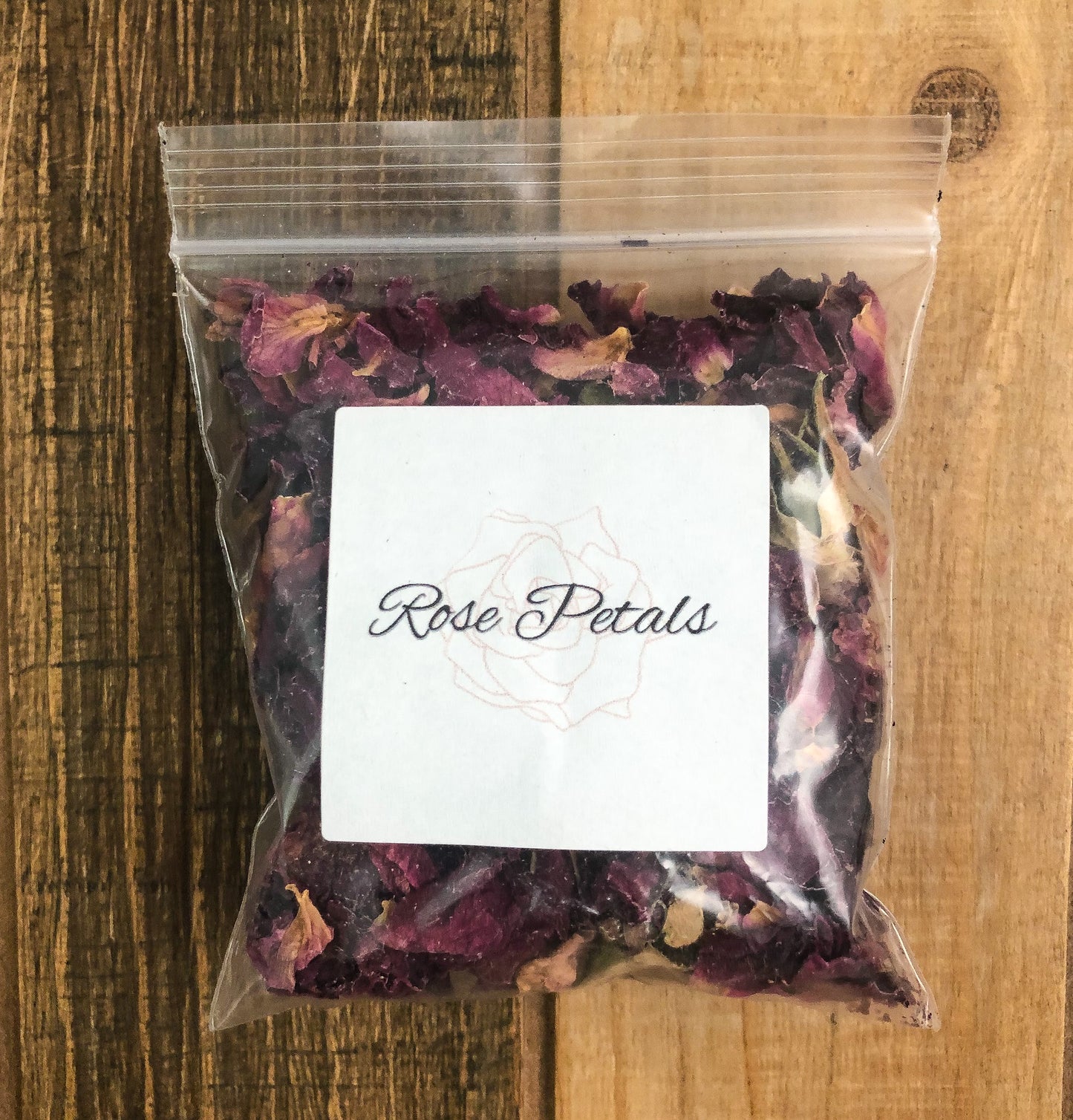 8g bag of dried roses in a clear plastic bag with a wooden background