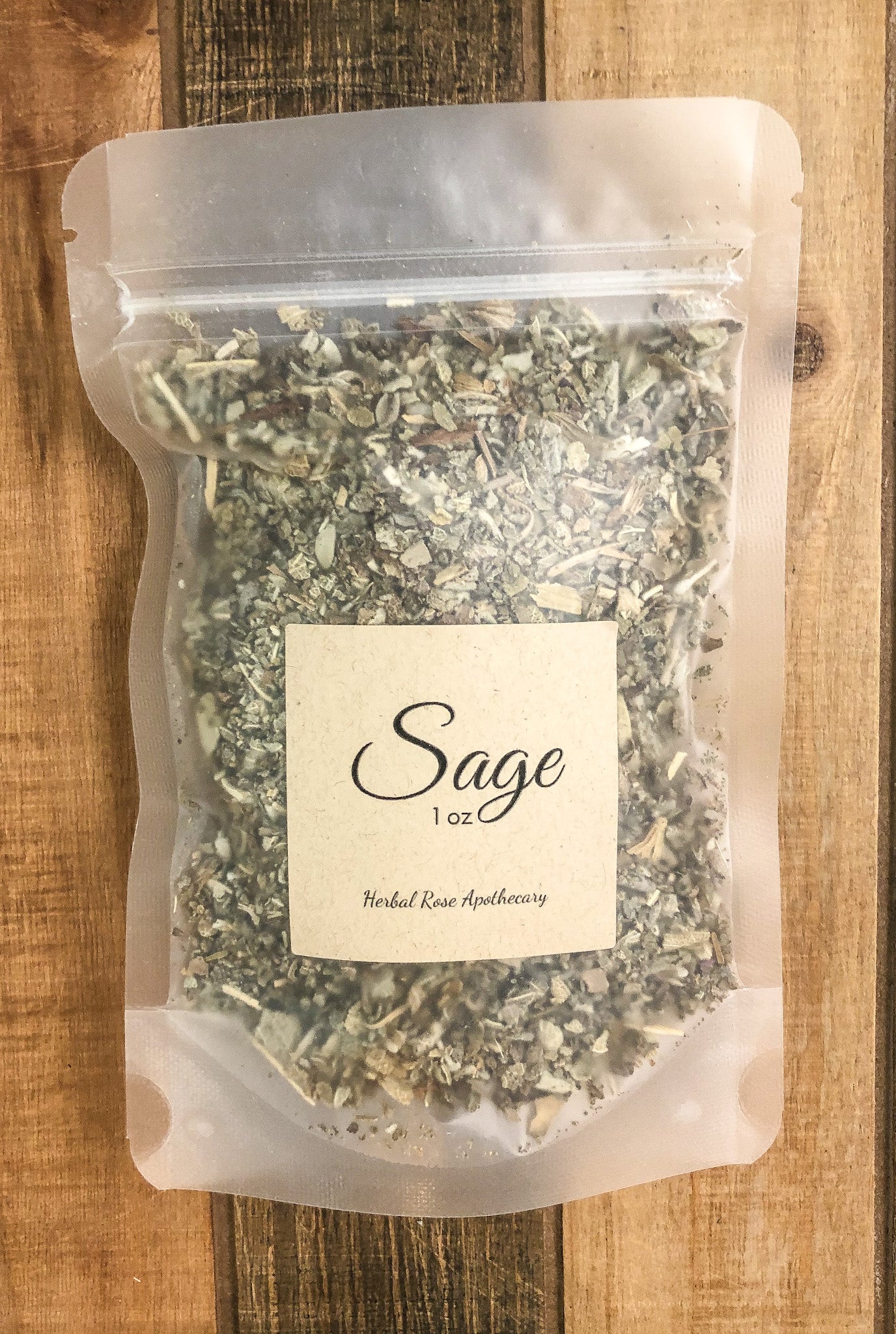 1oz bag of dried sage in a clear plastic bag with a wooden background